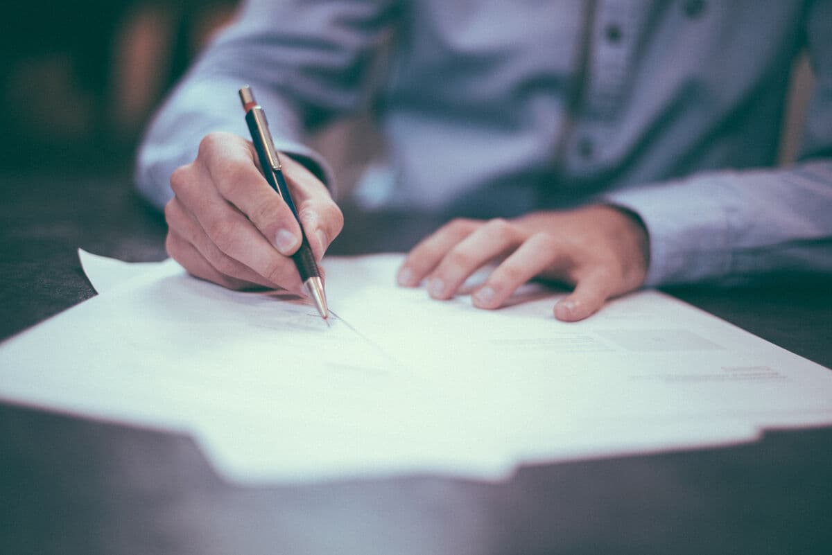 Hand signing bankruptcy application documents at a desk